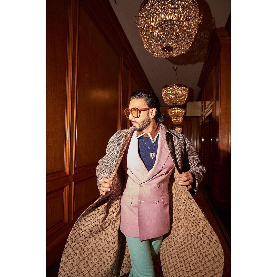 The ensemble is completed with bright blue tailored trousers and an oversized tweed jacket